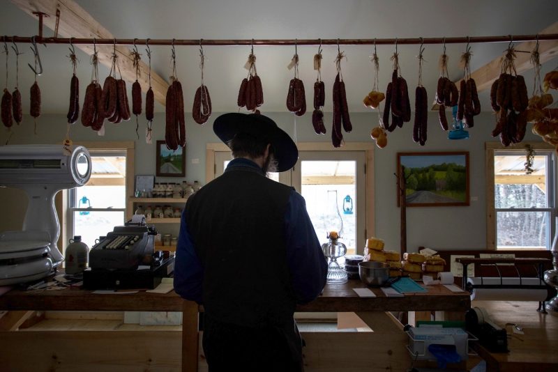 El charcutero Amish Matthew Secich, de espaldas en su establecimiento. Antes era chef de alta cocina y ha apostado por un modelo de vida con reducción tecnológica. Fotografía de Micky Bedell